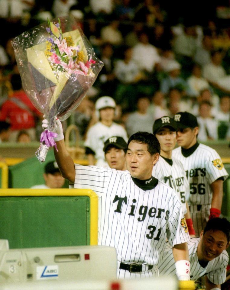 　広沢は左越えに通算３００号となる同点本塁打を放ち、ファンの声援に花束を振って応える＝２００１年９月１２日