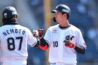 　１回、中前打を放ち根元コーチ（左）とグータッチを交わす上田（撮影・開出牧）