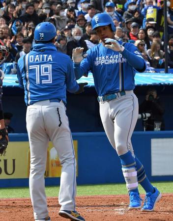 　４回、左越え本塁打を放ち代田コーチ（左）に迎えられる万波（撮影・持木克友）