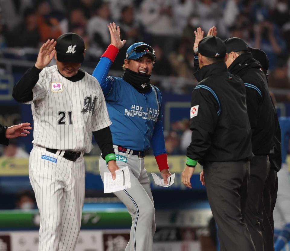 　メンバー表を交換し、審判団とハイタッチを交わす新庄監督（中央）と吉井監督（撮影・中島達哉）