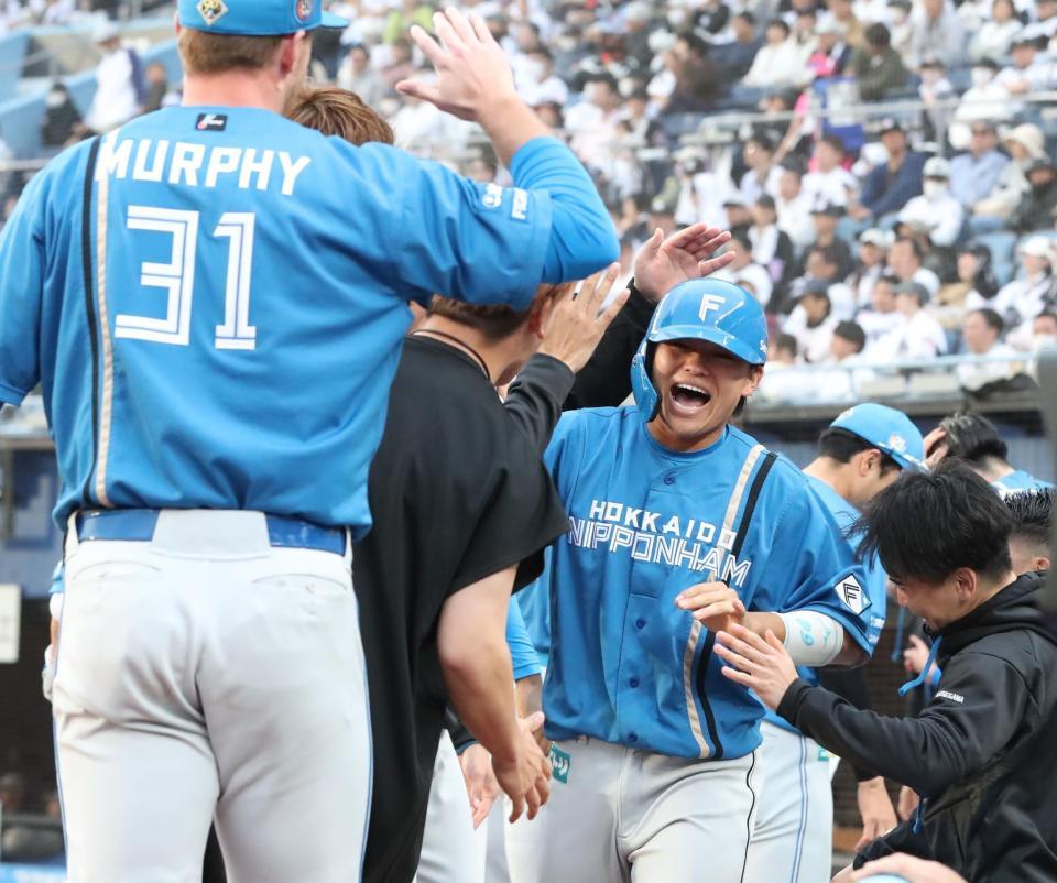 　９回、水野の勝ち越し打で生還し、ナインに迎えられる田宮（右）＝撮影・中島達哉