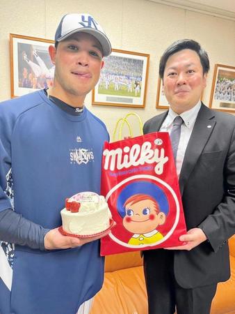 　不二家からサプライズでケーキが贈られた“燕のペコちゃん”ことヤフーレ（左）と同社・川崎健治量販課係長（右）＝球団提供