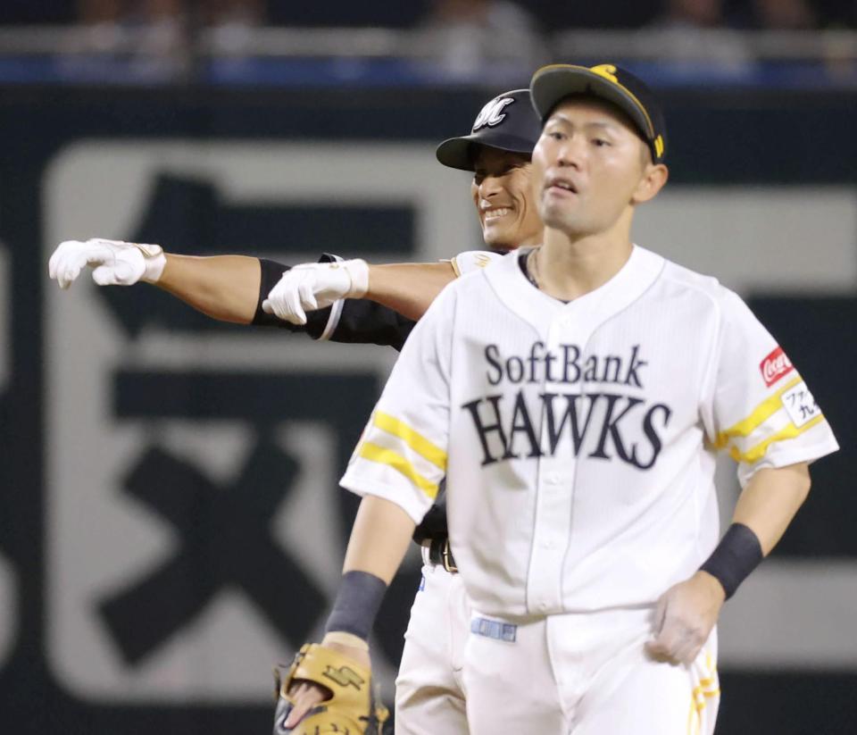 　１２回、決勝２点二塁打を放ち、笑顔の荻野。手前は一塁手中村晃（共同）