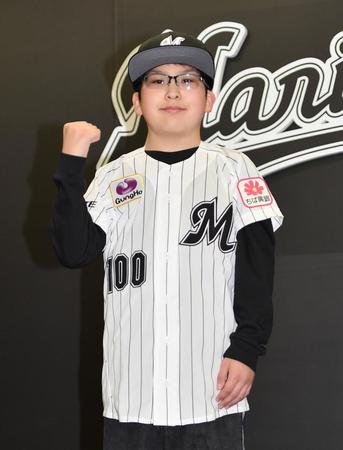 　入団会見で背番号１００のロッテのユニホームに袖を通しガッツポーズを決める山崎悠成くん（撮影・開出牧）
