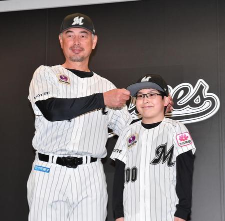 　入団会見で吉井監督（左）から背番号１００番のユニホームと帽子を贈呈され笑顔の山崎悠成くん（撮影・開出牧）