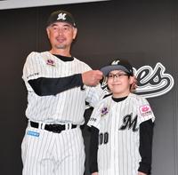 　入団会見で吉井監督（左）から背番号１００番のユニホームと帽子を贈呈され笑顔の山崎悠成くん（撮影・開出牧）