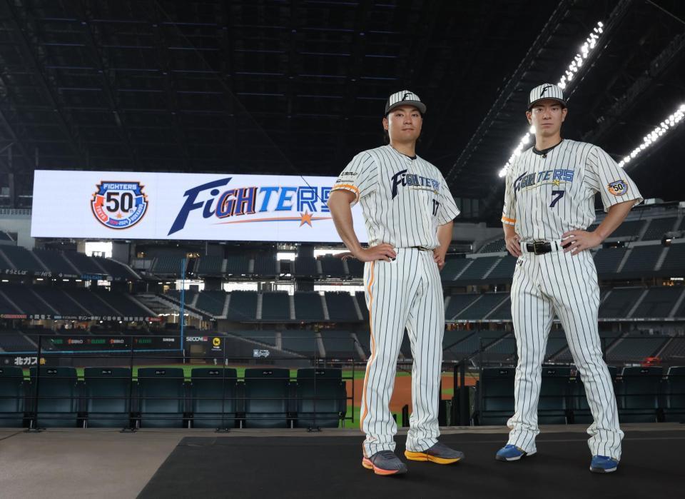 　「ファイターズ５０周年シリーズ」で着用する限定ユニホームを披露する（左から）伊藤、松本剛（撮影・中島達哉）