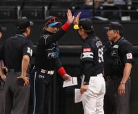 　メンバー表を交換し、小久保監督（右から２人目）とハイタッチを交わす新庄監督（中央）＝撮影・中島達哉