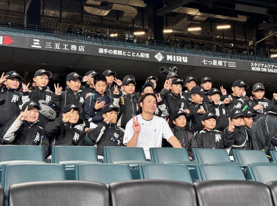 　試合前、子どもたちと記念撮影する伊藤（中央）＝撮影・中島達哉