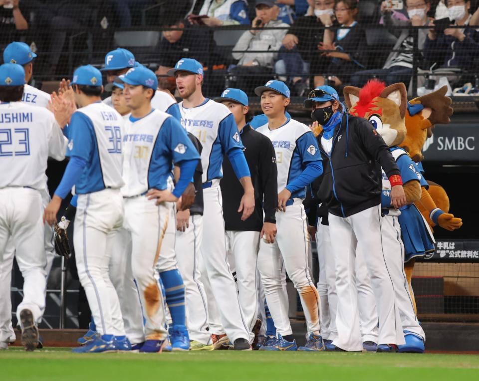 　勝利をあげ、ナインを迎える新庄監督（右）＝撮影・中島達哉