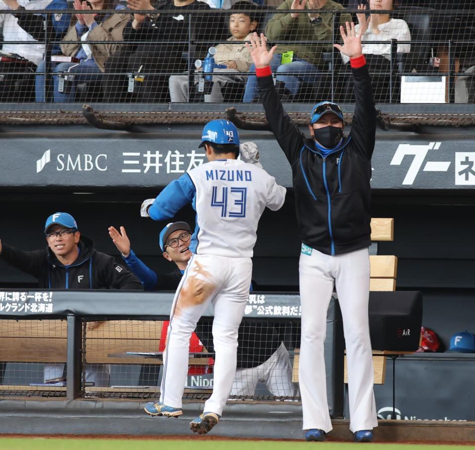 　８回、郡司の先制打で生還した二走・水野（４３）を迎える新庄監督（右）＝撮影・中島達哉