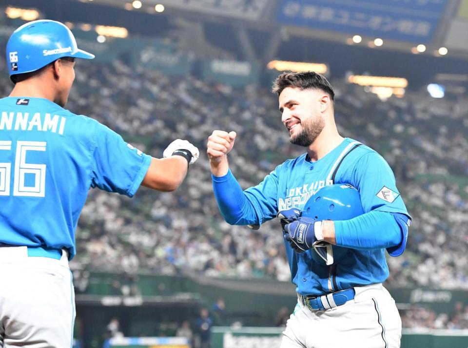 　８回、勝ち越しの犠飛を放ち、万波に出迎えられるマルティネス（撮影・佐々木彰尚）