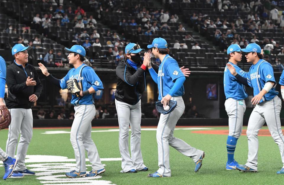 　完投で３勝目を挙げた山崎を出迎える新庄監督（撮影・佐々木彰尚）