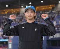 　カメラマンの要望に応えてガッツポーズをする鈴木（撮影・坂部計介）