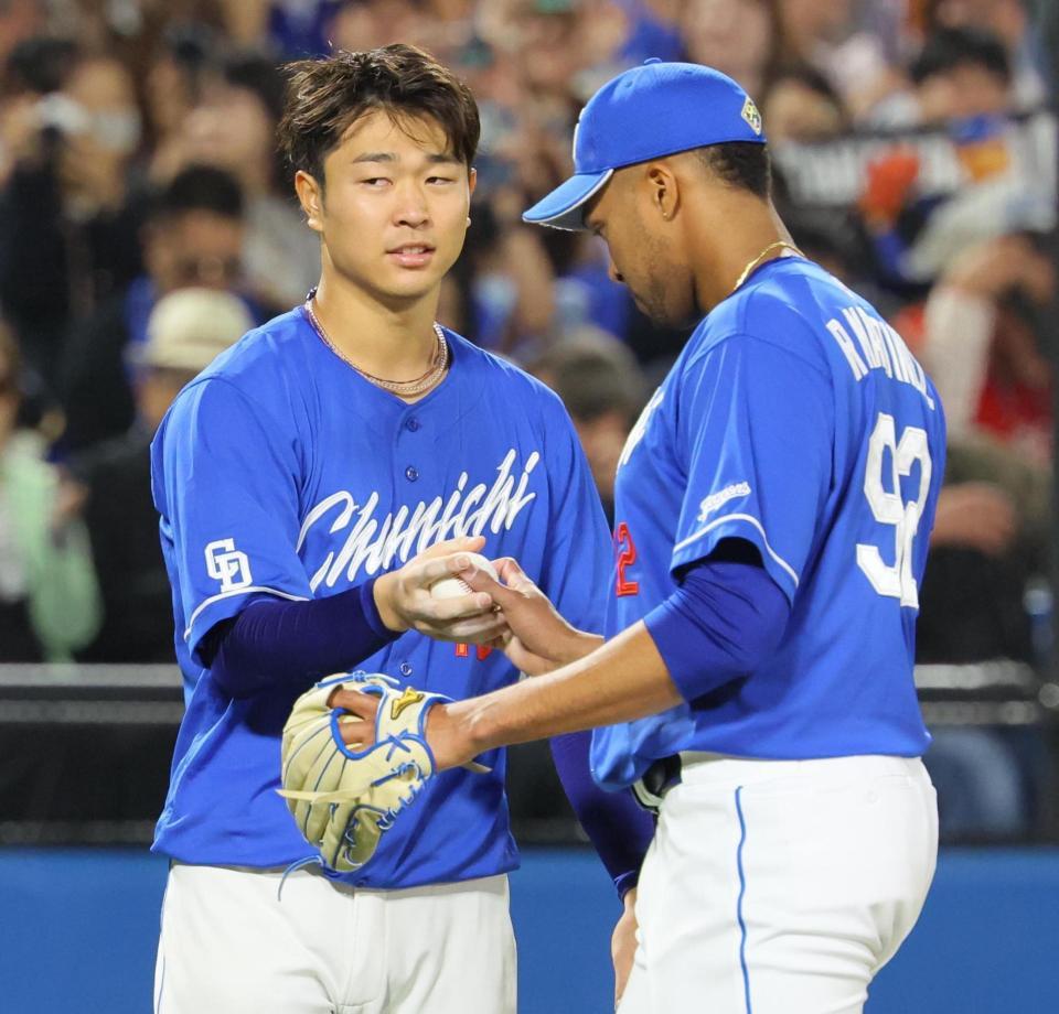 　最後を抑えたマルティネス（右）からウイニングボールを受け取る高橋宏（撮影・吉澤敬太）