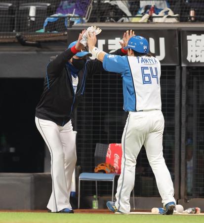 　６回、勝ち越し打を放った田宮（右）をハイタッチで迎える新庄監督（撮影・中島達哉）