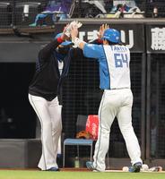 　６回、勝ち越し打を放った田宮（右）をハイタッチで迎える新庄監督（撮影・中島達哉）