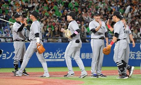 　今季初の首位に立ちナインを迎える阿部監督（左）＝撮影・佐藤厚