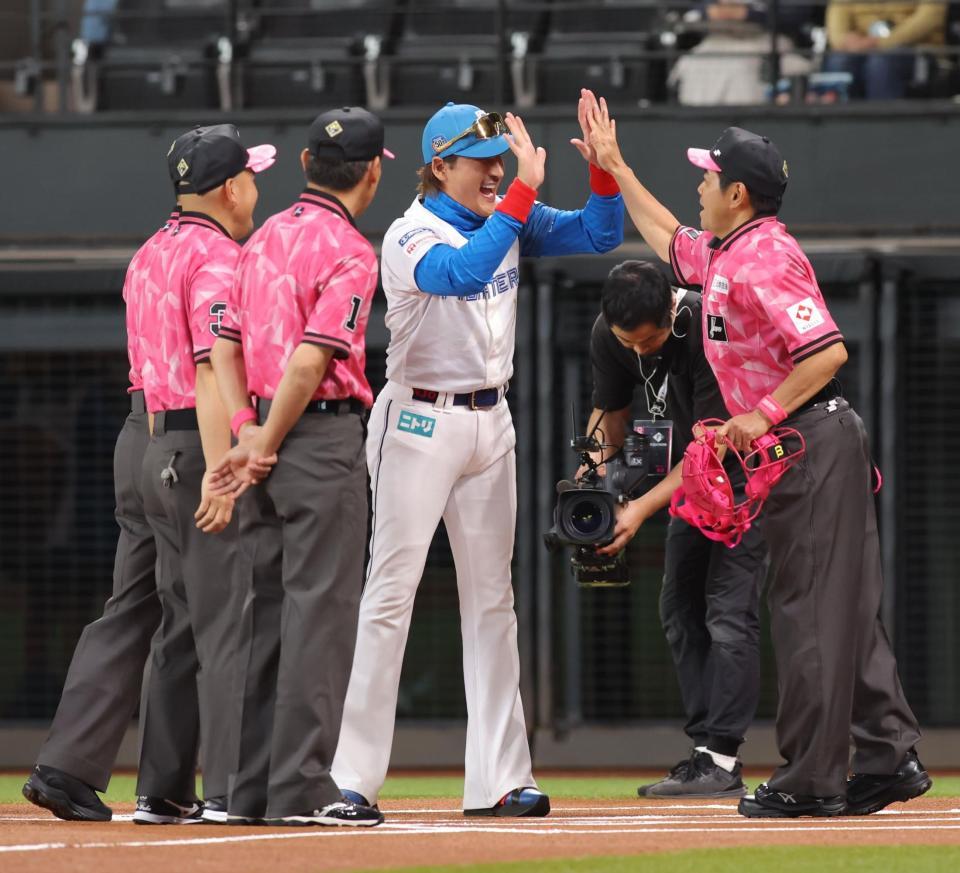 　メンバー表を交換後、球審とハイタッチを交わす新庄監督（中央）＝撮影・中島達哉