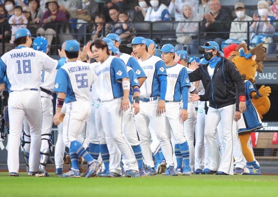 　４勝目をあげた山崎（左端）らを迎える新庄監督（右）＝撮影・中島達哉