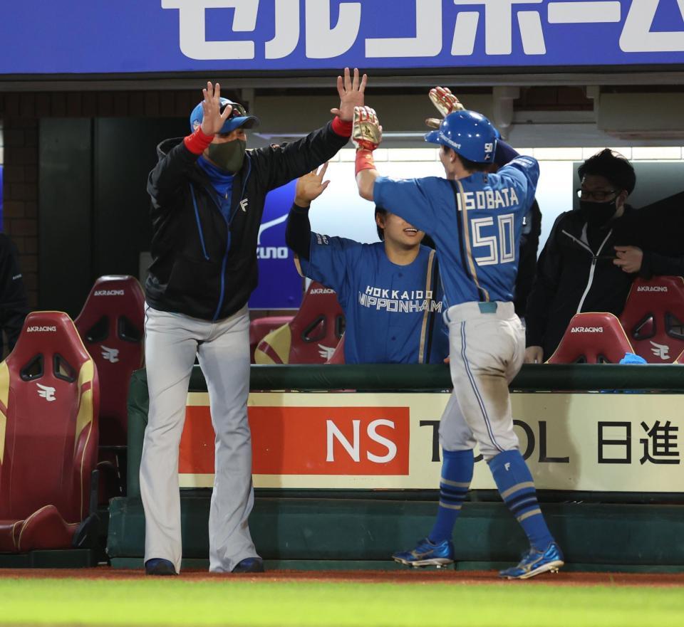 　１０回、松本剛の遊ゴロが悪送球となり勝ち越し、生還した五十幡を迎える新庄監督（撮影・金田祐二）