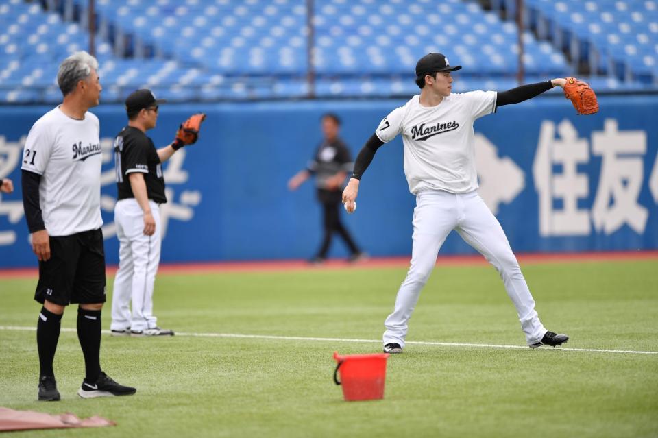 　試合前の練習でキャッチボールする佐々木（右）。左端は吉井監督（撮影・開出牧）