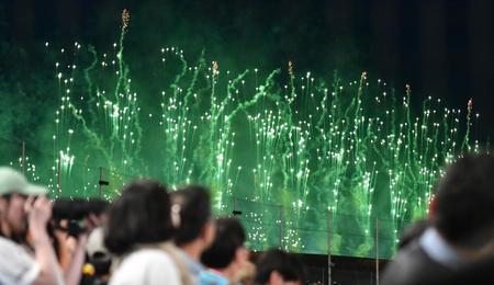 　国立競技場から上がる花火を見る観客（撮影・開出牧）