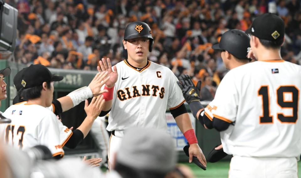 　３回、１イニングに２本の適時打を放ち、ナインに迎えられる岡本（中央）＝撮影・佐藤厚