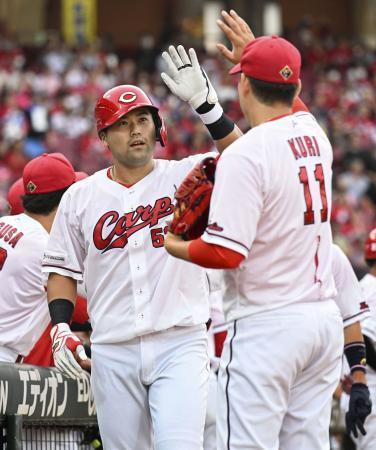 　１回、先制２ランを放ち、九里（右）に迎えられる広島・末包＝マツダ