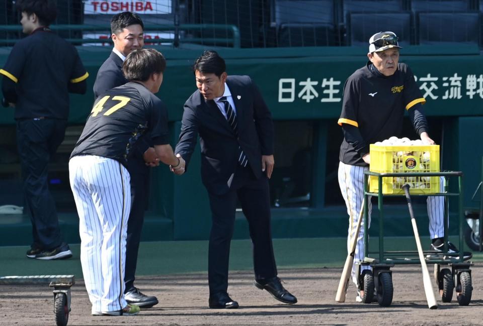 　あいさつに来た桐敷（４７）と握手する井端監督（撮影・飯室逸平）