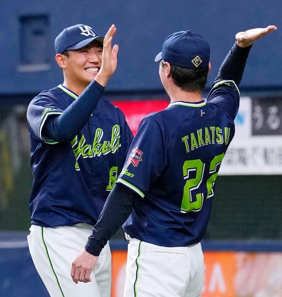 　３季ぶりの勝利を挙げ、高津監督（右）とタッチを交わす奥川