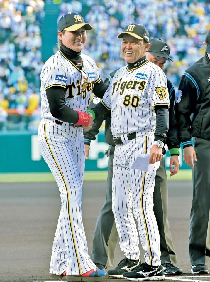 　阪神のユニホーム姿で岡田監督（右）と握手を交わす新庄監督＝５月２９日