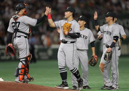 　ヤクルトに勝利し、ナインとタッチを交わす岡本和（中央）＝撮影・西岡正