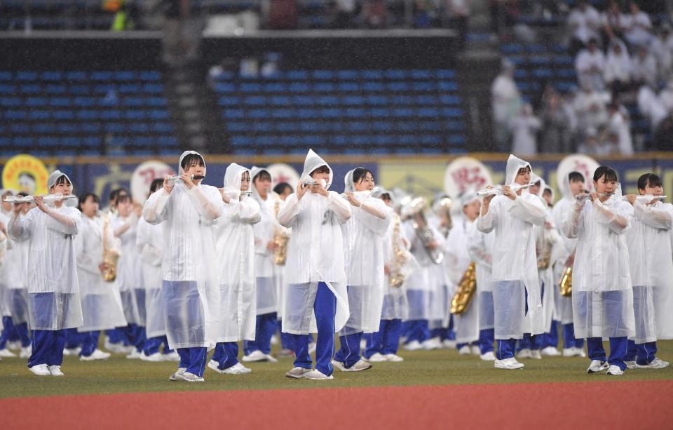 　試合前、雨の中で演奏する習志野高等学校吹奏楽部（撮影・開出牧）