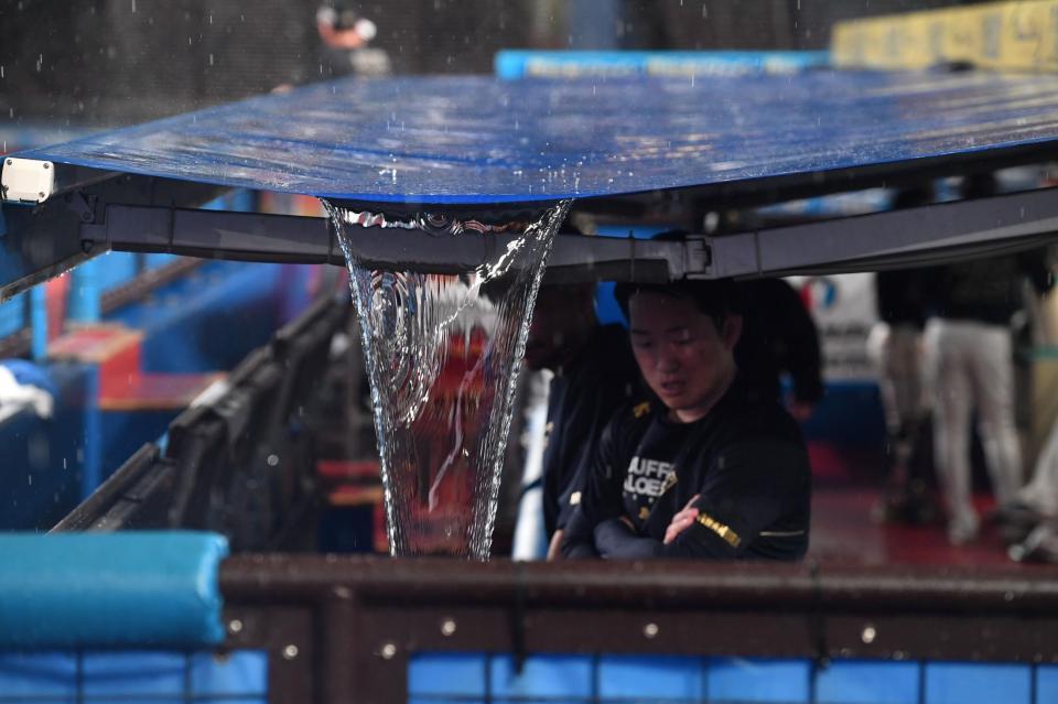 　オリックスナインが待機する三塁側ベンチの屋根から滝のような雨水が流れ落ちる（撮影・開出牧）