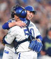 　完封勝利で今季２勝目を挙げ山本（右）と抱き合う平良（撮影・開出牧）