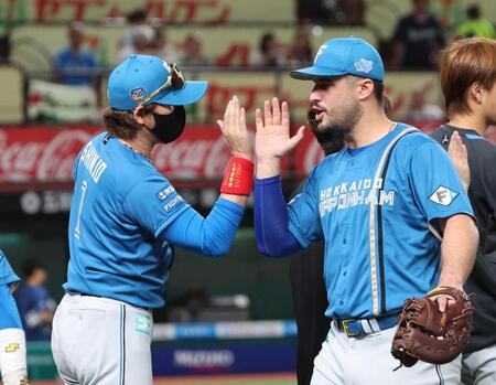 　西武に連勝し、マルティネス（右）とタッチを交わす新庄監督