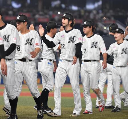 　今季２勝目を挙げナインとタッチを交わす石川歩（中央）＝撮影・開出牧