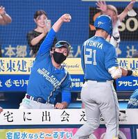 　７回、勝ち越しの右越えソロを放った清宮（右）とタッチを交わしガッツポーズを決める新庄監督（撮影・開出牧）