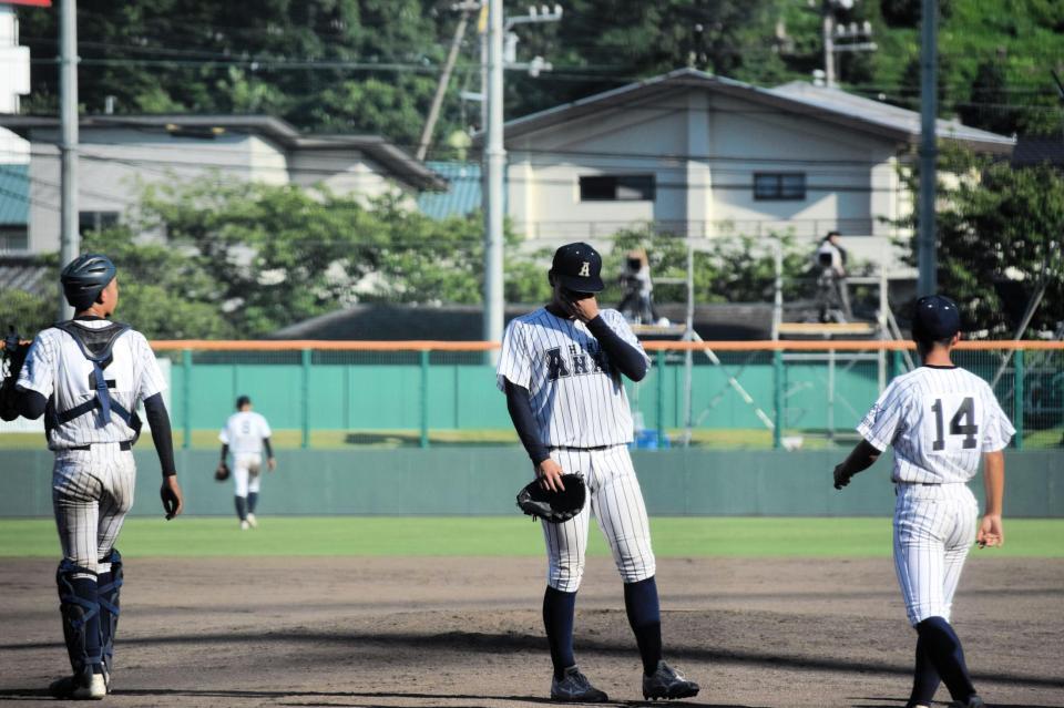 　サヨナラ負けしてマウンドで顔を覆う阿南光の吉岡（右から２人目）