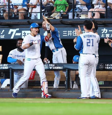 　７回、勝ち越しとなる押し出し死球を受け、ナインに迎えられる野村（左から２人目）＝撮影・中島達哉