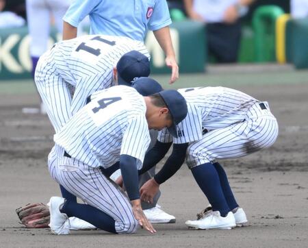 　６回、二ゴロを処理後、足を痛めた二塁手の明徳義塾・平尾成歩（中央）＝撮影・伊藤笙子