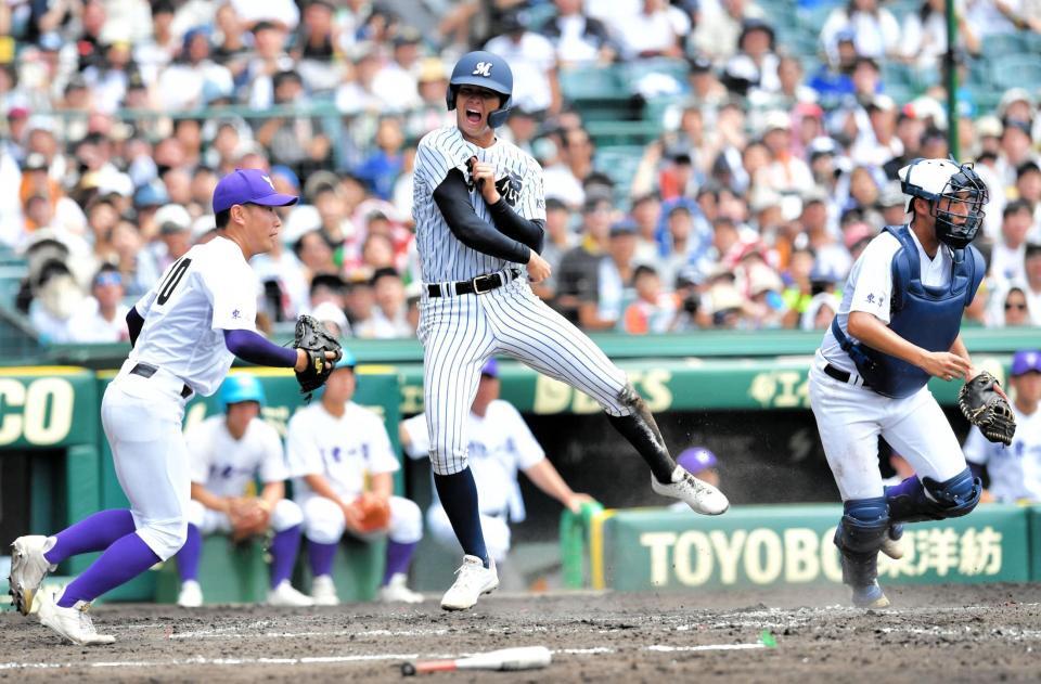 　３回、本塁生還し、勝ち越しに喜ぶ明徳義塾・長谷川烈央（中央）＝撮影・今井雅貴