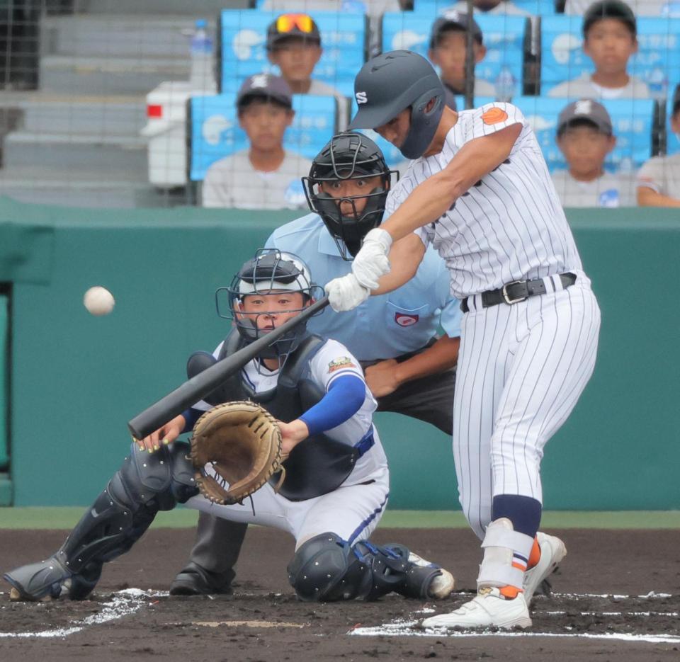 　１回、右越えの先制打を放つ滋賀学園・岡田。捕手は霞ケ浦・片見