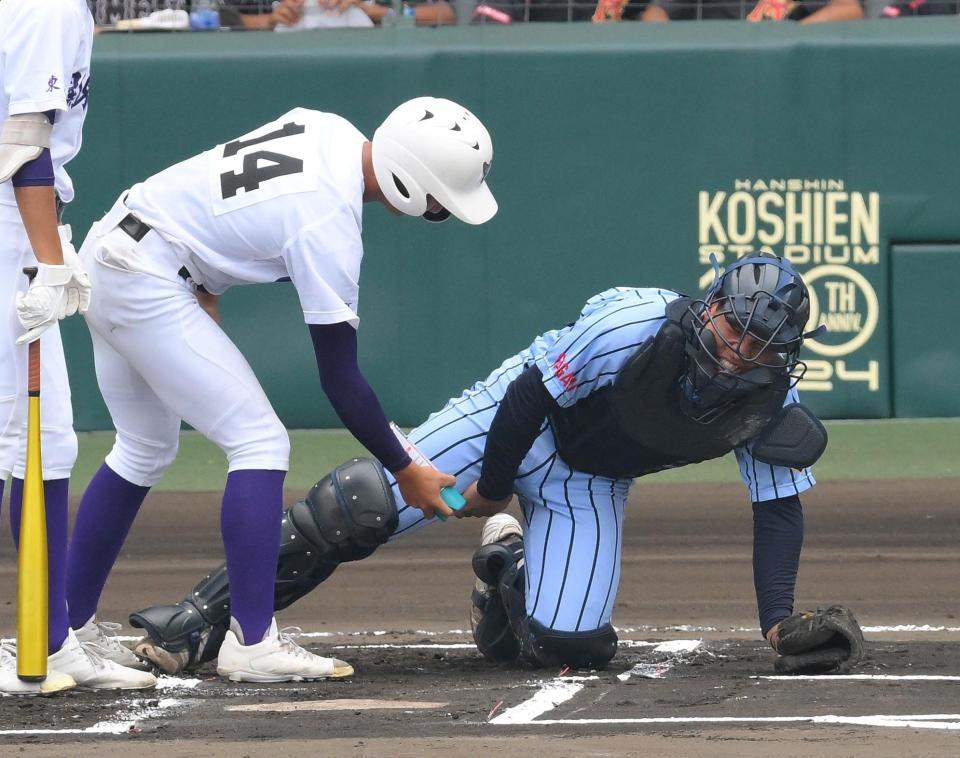 　６回、成井聡のファウルが直撃した東海大相模・木村海達（右）にコールドスプレーを吹きかける関東一・中里駿介（撮影・伊藤笙子）