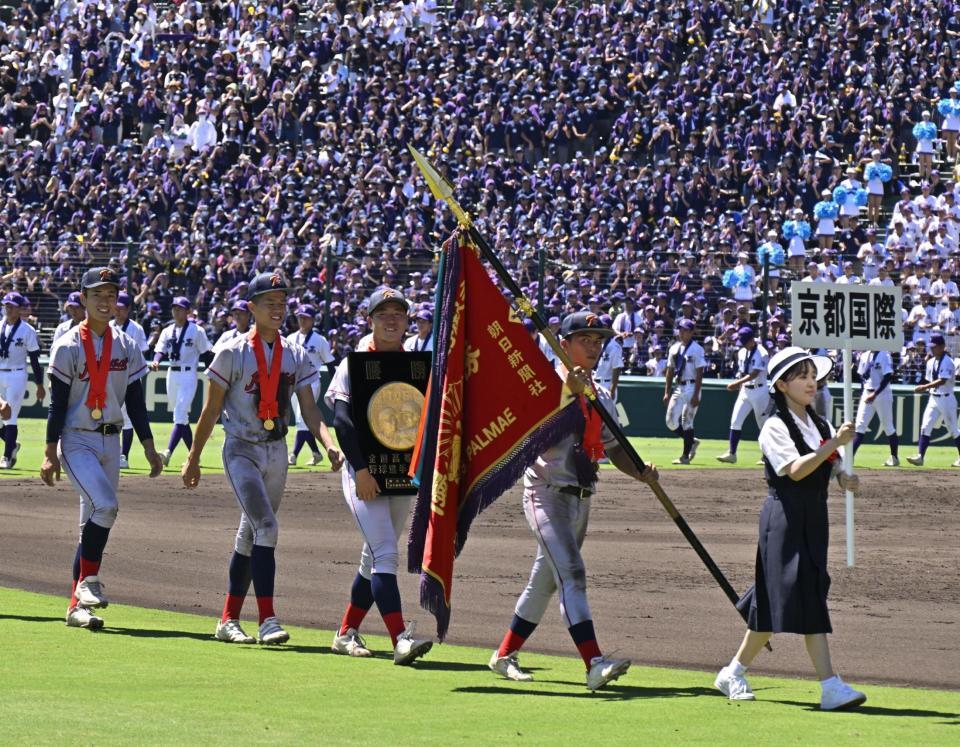 　優勝旗と表彰盾を手に、グラウンドを行進する京都国際ナイン（撮影・今井雅貴）