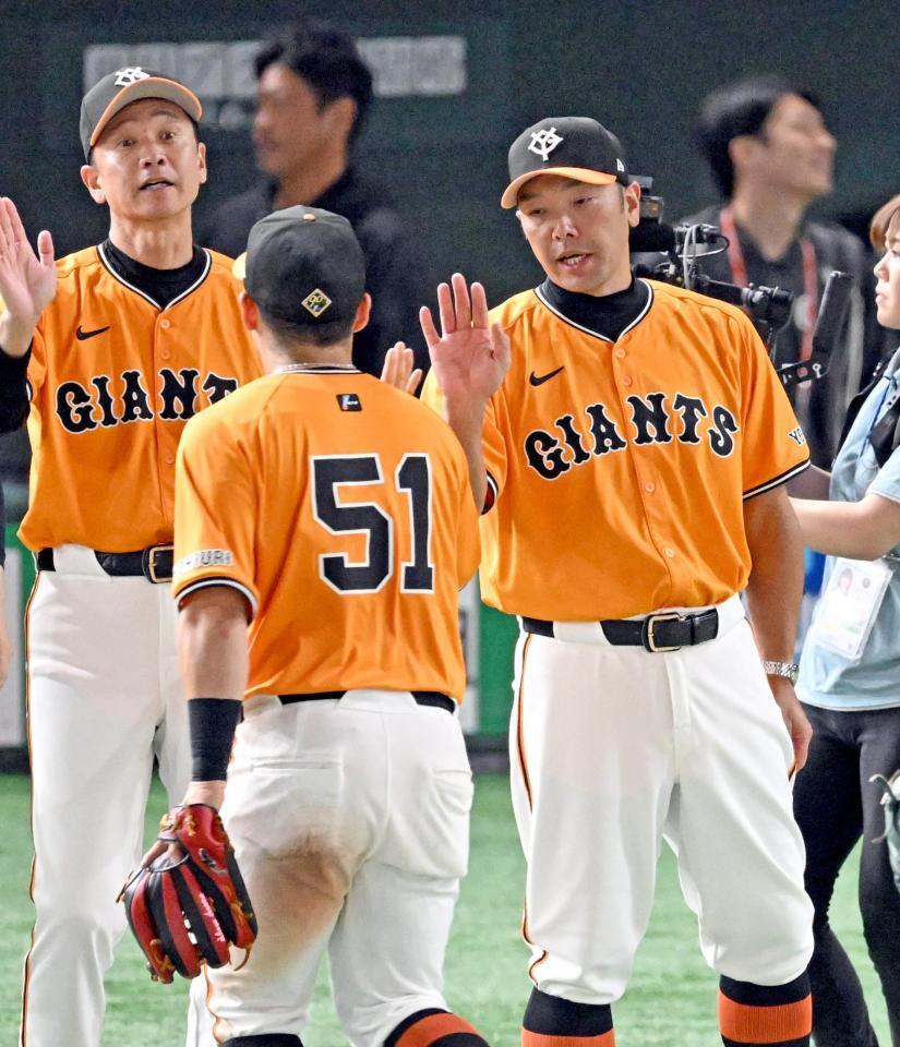 　中日に勝利し、浅野（５１）らナインとタッチを交わす阿部監督（右）