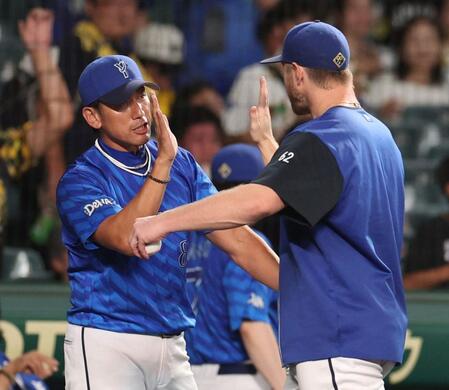 　今季５勝目を挙げたウィック（右）を迎える三浦監督（撮影・中田匡峻）