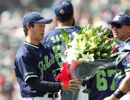 　今季限りで現役引退を表明している青木（右）は岡田監督から受け取った花束を見つめる（撮影・中田匡峻）