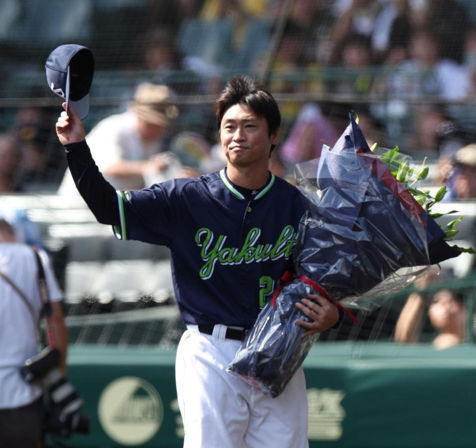 　今季限りで現役引退を表明している青木（右）は岡田監督から花束を受け取る（撮影・中田匡峻）